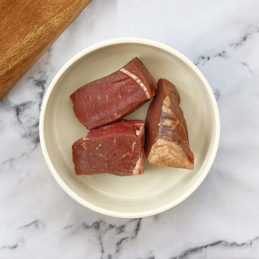 Beef chunks in a dog bowl