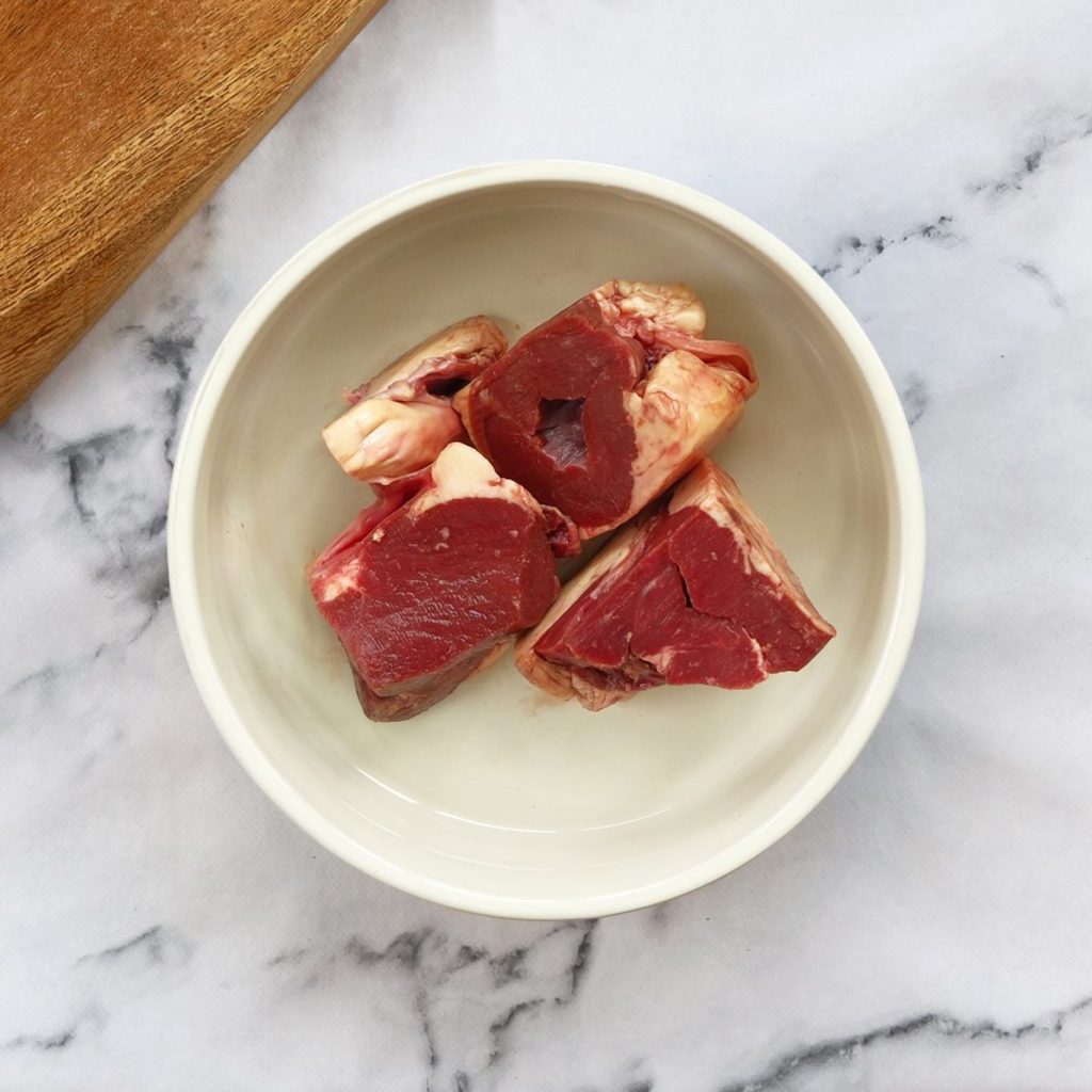 Beef heart chunks in a dog bowl