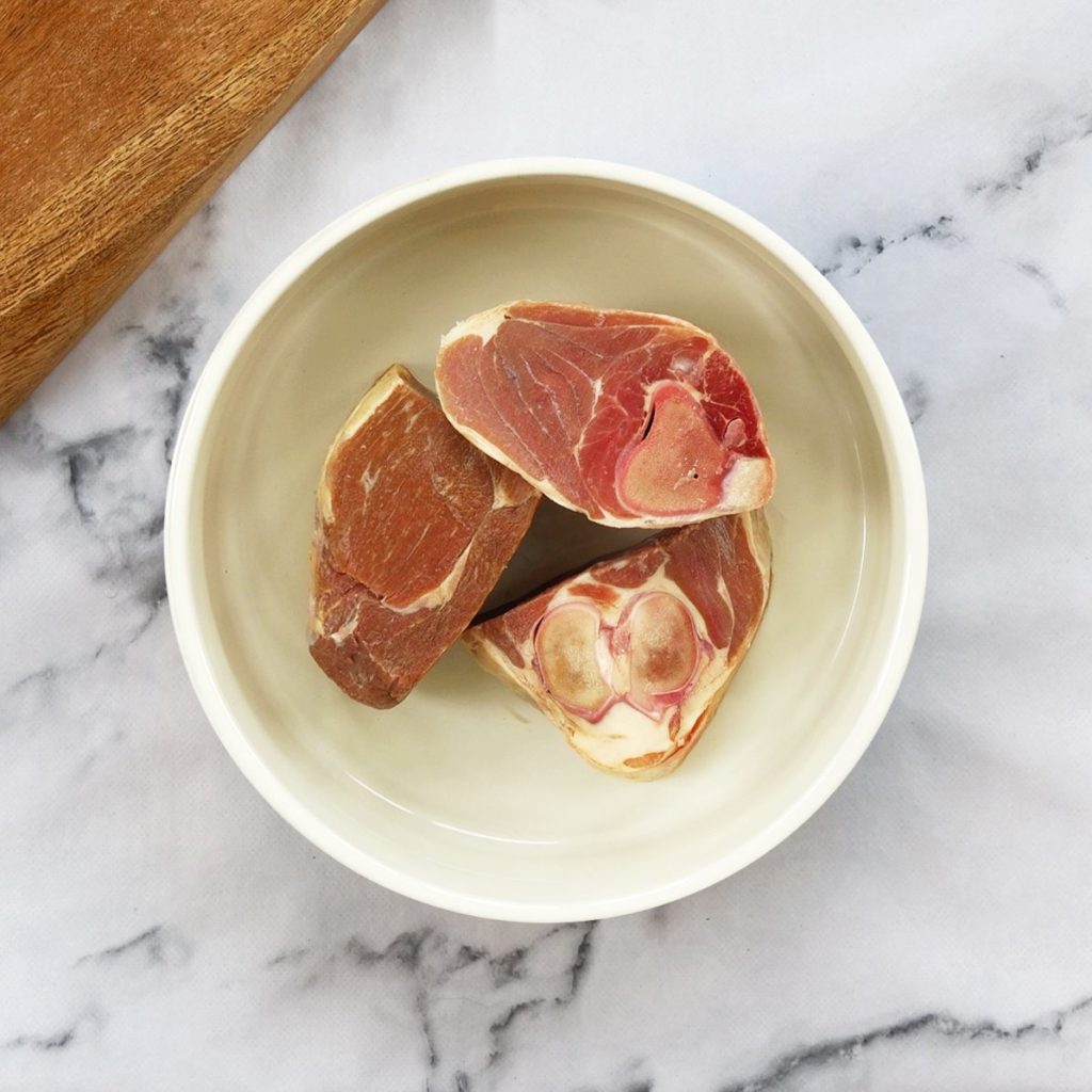 Lamb leg chunks in a dog bowl